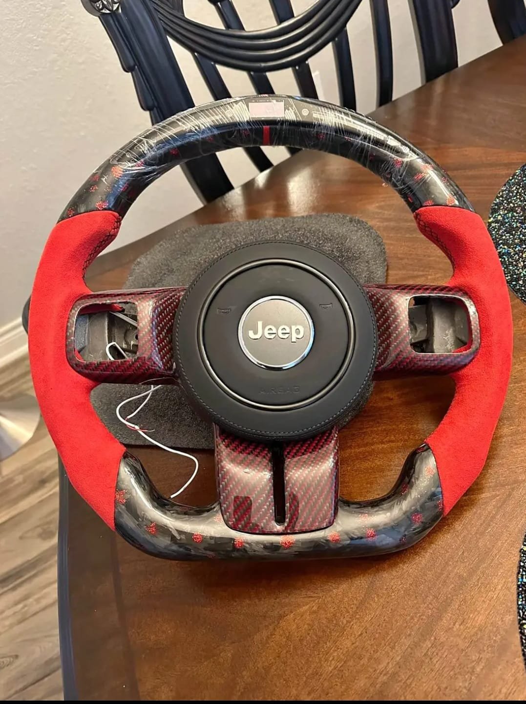 WhatsApp Image 2025-12-06 at 7.56.24 AM custom carbon fiber and red suede steering wheel for a Jeep Wrangler. - Image 1